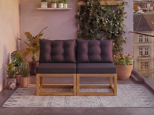 Canapea modulară din lemn de două locuri cu perne gri &icirc;nchis pe un balcon &icirc;nconjurat de plante la ghiveci și priveliște spre oraș &icirc;n fundal