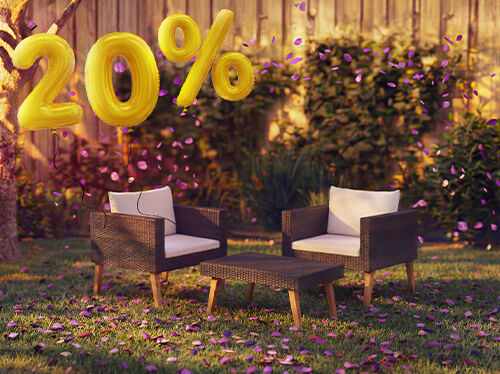 Fotolii lounge din ratan pentru exterior cu perne și o măsuță &icirc;ntr-un decor de grădină, decorate cu confetti roz și baloane aurii &bdquo;20% reducere&rdquo;, evidențiind oferte sezoniere la mobilier lounge de grădină.
