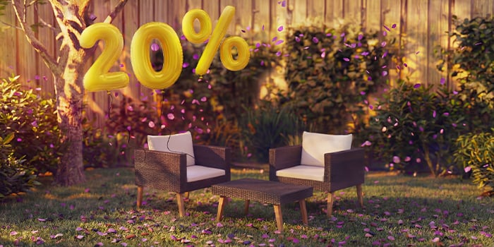  Fotolii lounge din ratan pentru exterior cu perne și o măsuță într-un decor de grădină, decorate cu confetti roz și baloane aurii „20% reducere”, evidențiind oferte sezoniere la mobilier lounge de grădină.
